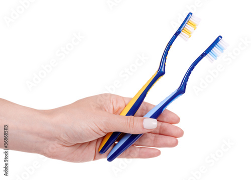 Hand with blue and yellow plastic toothbrush, dental care. Isolated on white background.