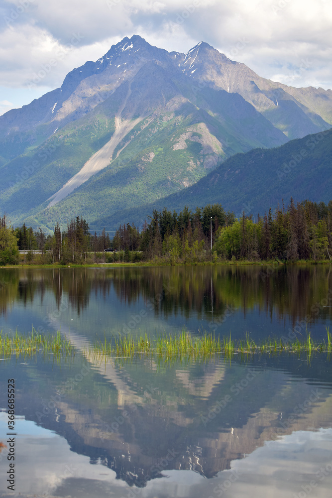 Pioneer Peak towers over Reflections Lake at the edge of Alaska's Chugach Range.