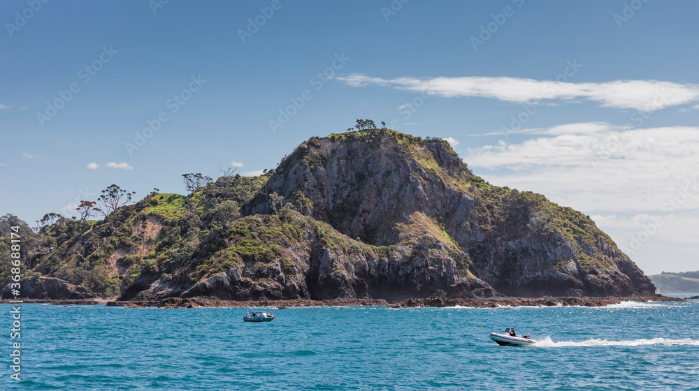 Rocky coastline and boats in Bay of Islands, New Zealand