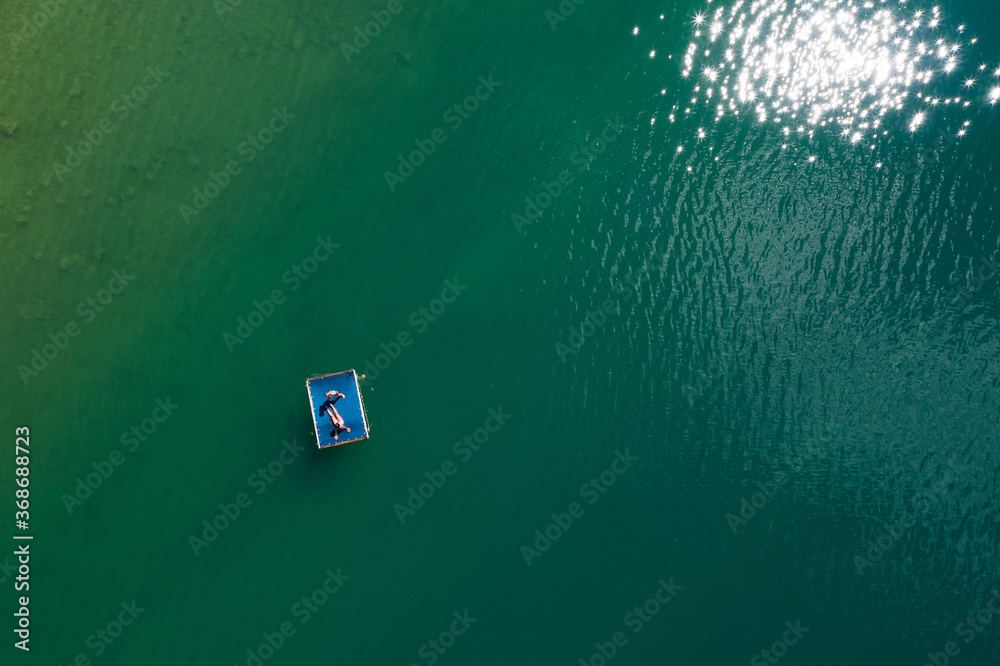 Εκτύπωση καμβά Floating platform with a sun tanning couple aerial top view