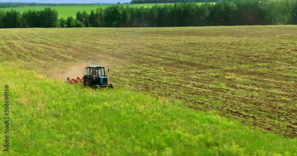 Tilling the land with a tractor, plowing the field. Tractor plows the soil in the field. Circular movement of the camera. View from above. 4k, 10bit, ProRes Tilling the land with a tractor, plowing the field. Tractor plows the soil in the field. Circular movement of the camera. View from above. 4k, 10bit, ProRes