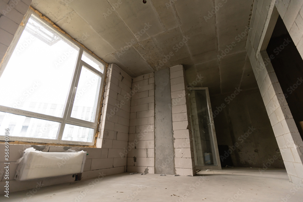 A new unfinished apartment room with the bare brick walls without decoration. A new unfinished apartment room with the bare brick walls without decoration.