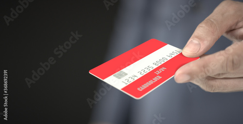 Man gives plastic bank card with printed flag of Austria. Fictional numbers