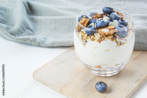 Healthy blueberry and walnut parfait in a glass on a white background