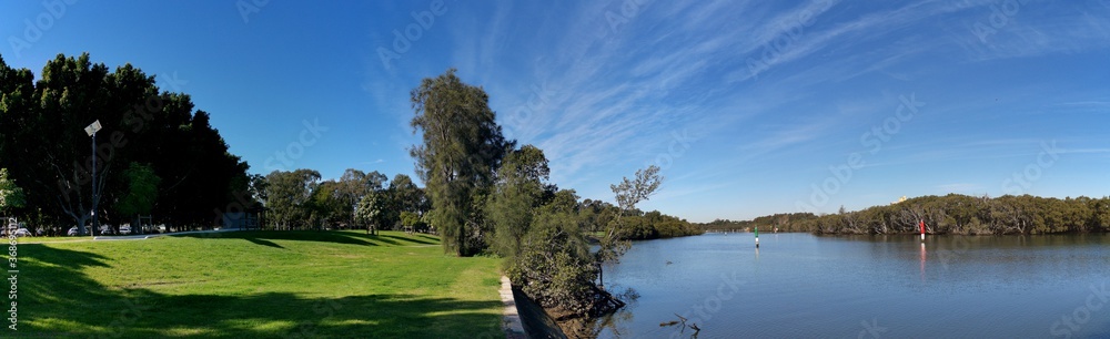 Beautiful panoramic view of a river with reflections of blue sky, light clouds and trees on water, Parramatta river, Rydalmere, New South Wales, Australia Beautiful panoramic view of a river with reflections of blue sky, light clouds and trees on water, Parramatta river, Rydalmere, New South Wales, Australia