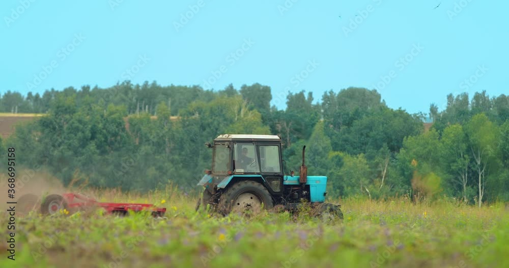 Tractor driver cultivates land in the field, preparing for sowing grain. Field agrotechnical work. Beautiful rural landscape. 4k, 10bit, ProRes Tractor driver cultivates land in the field, preparing for sowing grain. Field agrotechnical work. Beautiful rural landscape. 4k, 10bit, ProRes