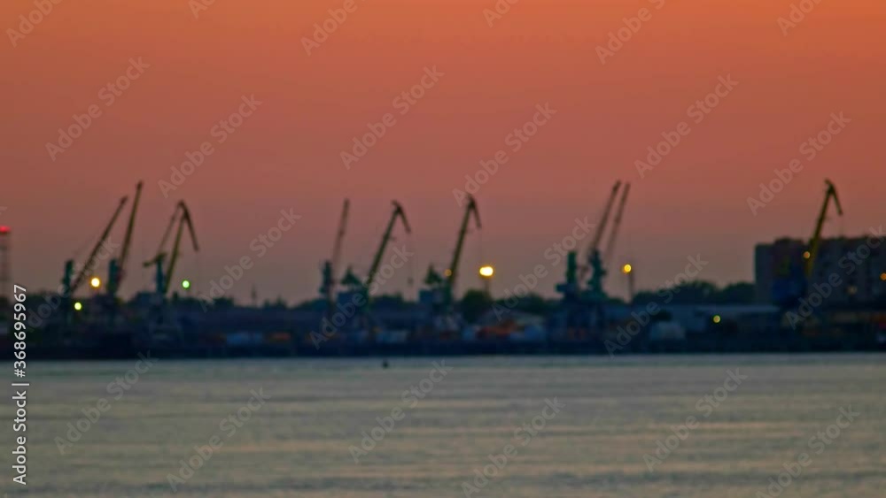 Blurred harbour cranes working in sunset light time-lapse video Blurred harbour cranes working in sunset light time-lapse video