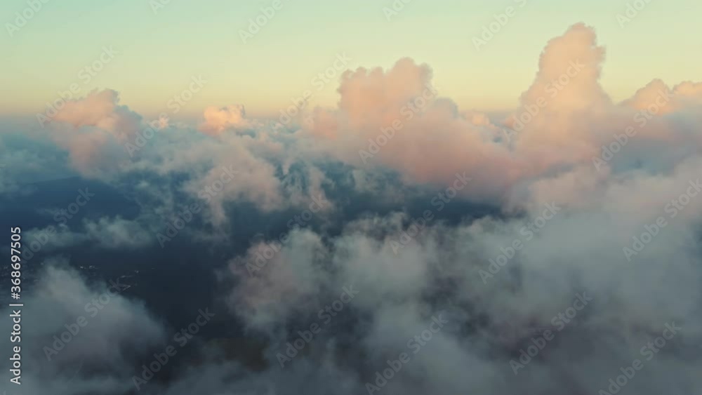 Moving white clouds blue sky scenic aerial view sunrise. Drone flies high back in blue sky through fluffy clouds in morning at bright sun summer. Sun is hidden behind clouds at fog. Relax. Nature Moving white clouds blue sky scenic aerial view sunrise. Drone flies high back in blue sky through fluffy clouds in morning at bright sun summer. Sun is hidden behind clouds at fog. Relax. Nature