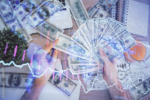 Multi exposure of financial graph drawing hologram and USA dollars bills and man hands. Analysis concept. © peshkova