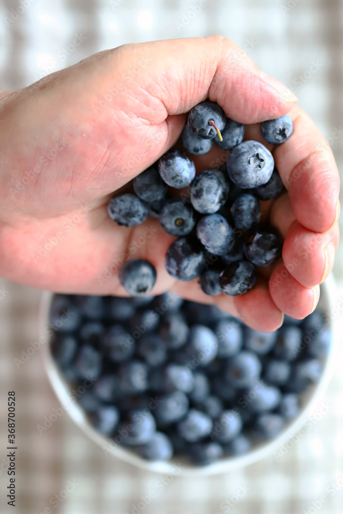 Selective focus. Macro. Blueberries in a man's hand. A man's hand holds blueberries. Selective focus. Macro. Blueberries in a man's hand. A man's hand holds blueberries.