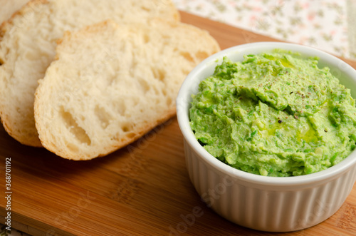 Ricotta pate with peas in a jar served with sliced Italian bread.