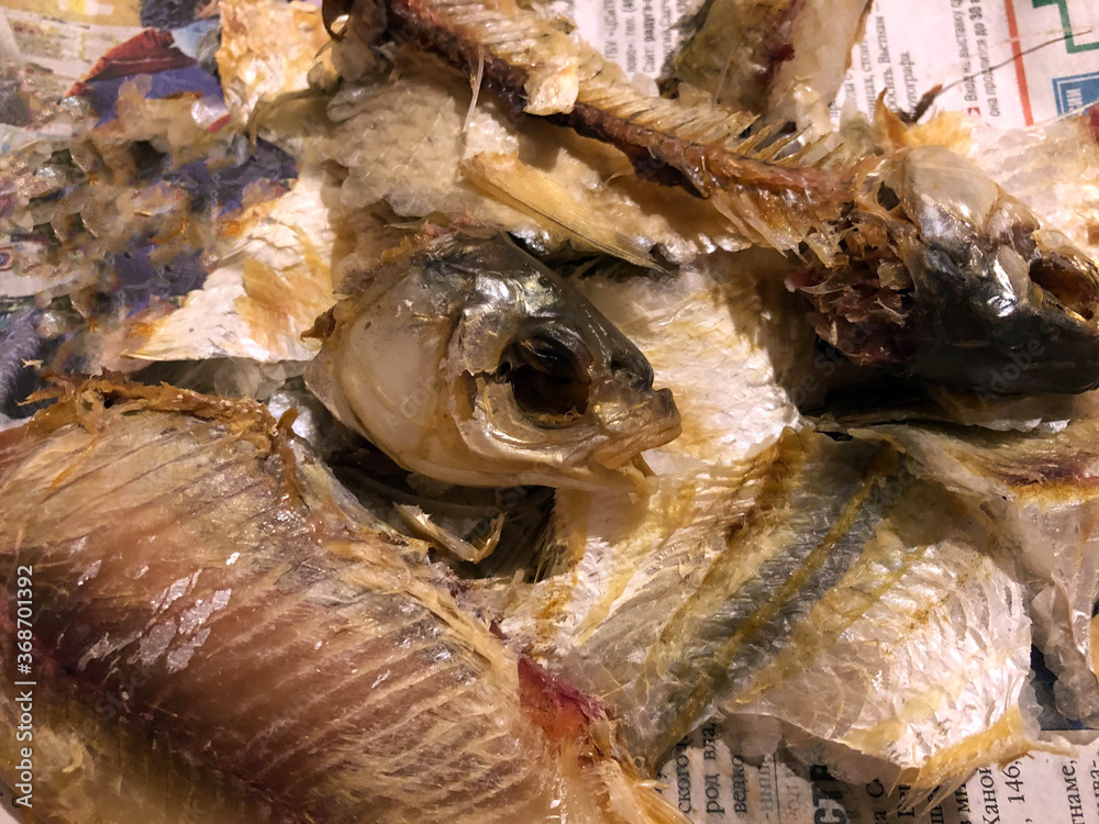 Salted fish cleanings are on the newspaper, a severed head and a fish