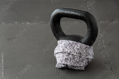 Fitness during a pandemic, fabric face mask and a black kettlebell 