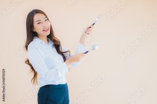 Portrait beautiful young asian business woman with spoon and fork