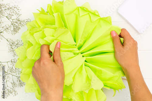 Step by step tutorial on making a light green fluffy pom-pom from tissue paper. Top view. Step 9 photo