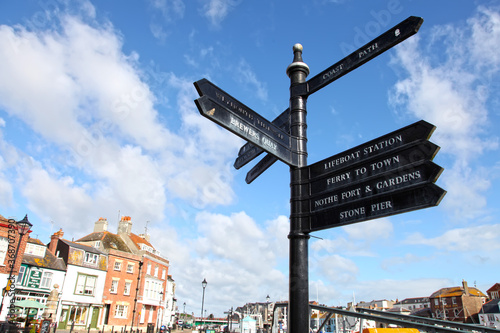 Directional sign post near the harbour in Weymouth, Dorset, England, UK.