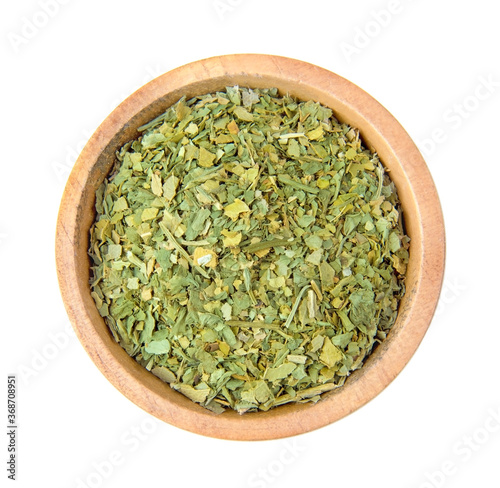 dried oregano seasoning in a wooden bowl, top view. spice isolated on white