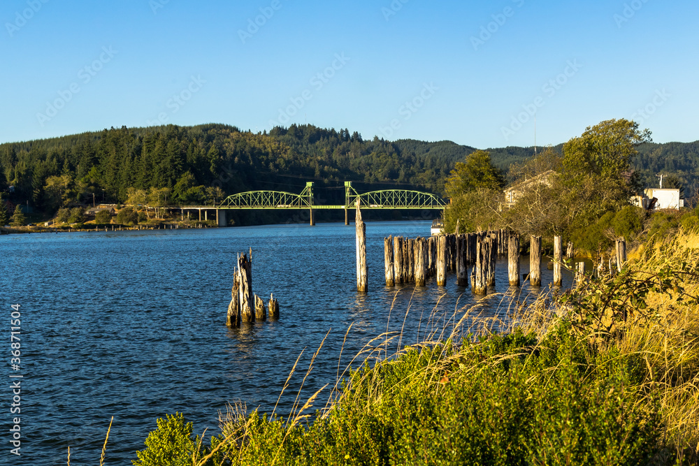 Fototapeta premium Landscape with a bridge over river in summer day. Millicoma river, Oregon