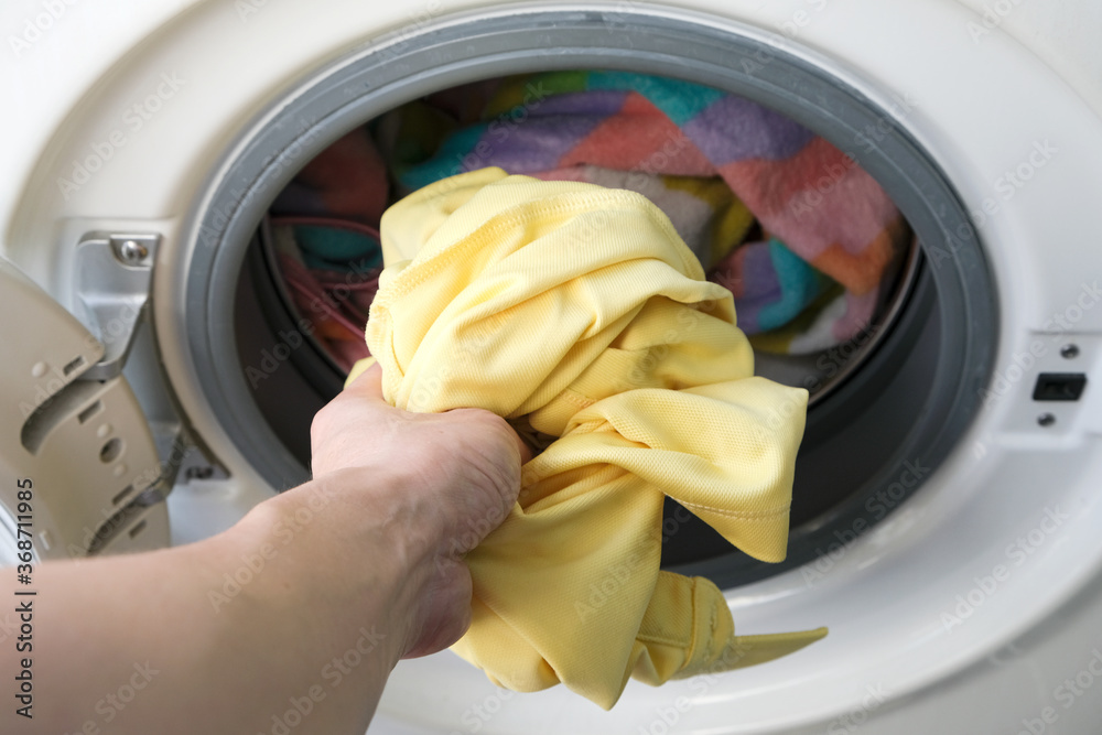 Woman's hand Pick up clothes Washing machine.Clean and Healthy Concepts. Woman's hand Pick up clothes Washing machine.Clean and Healthy Concepts.