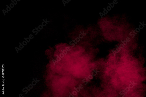 Abstract red powder dust explosion on black background.