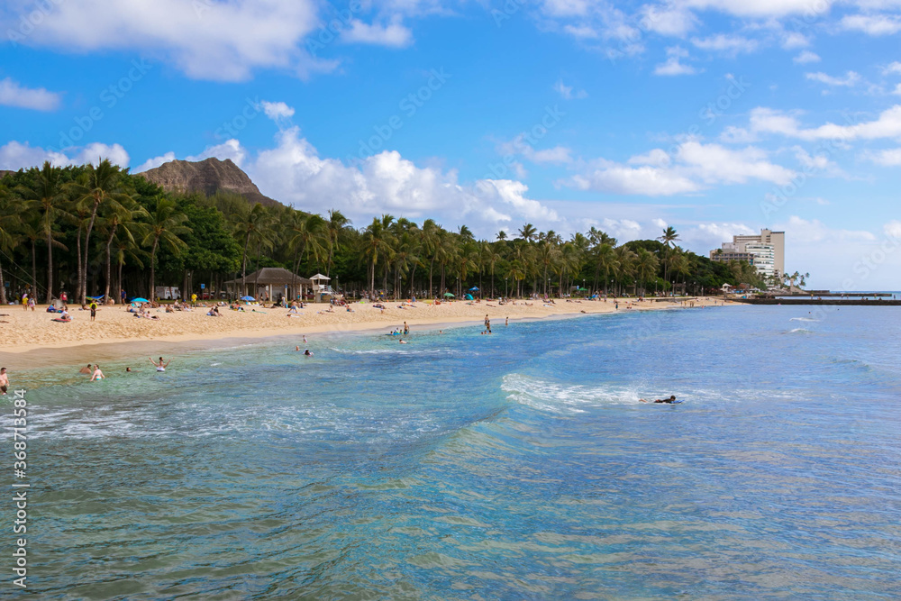 ハワイ・ホノルルのワイキキビーチに押し寄せる波と背景の青空