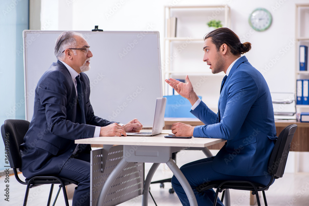 Yound and old employees in business presentation concept Yound and old employees in business presentation concept