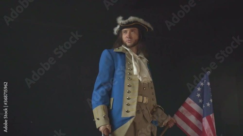 Officer in uniform of US Revolutionary War with pistol on black background. Historical concept