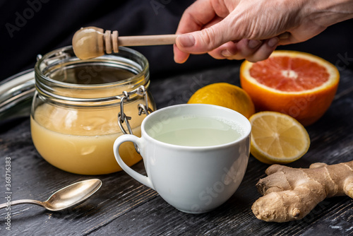 Process preparation of warming tea with ginger, honey and lemon. Concept of healthy tea for cold days or a flu
