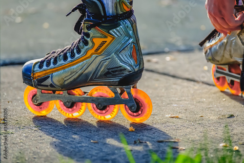 Fotografie Inline roller blade skates with glowing orange wheels
