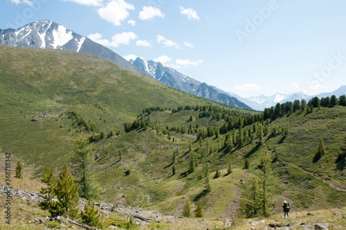 Landscape summer view of Altai mountains with unrecognizable tourist figure standing in the foreground, the Altai republic, Russia