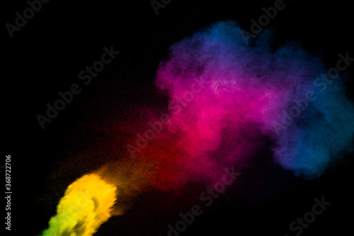 Abstract multi color powder explosion on black background. Freeze motion of colorful dust particles splash. Painted Holi.