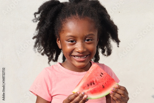 Child Little Black Girl smiling holding watermelon with white background outdoors