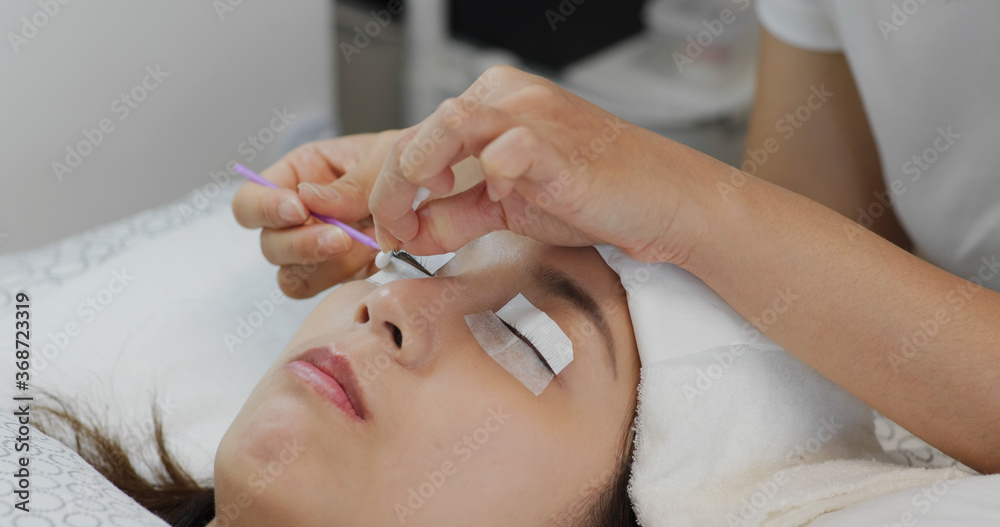 Woman perm her eyelash at beauty salon Woman perm her eyelash at beauty salon