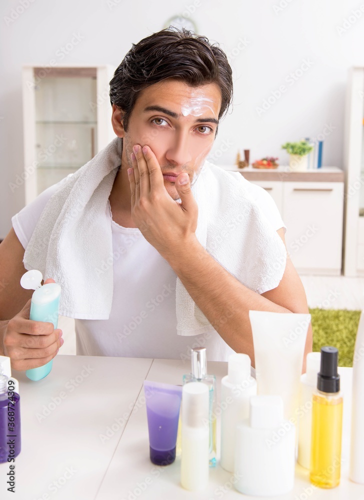 Young handsome man in the bathroom in hygiene concept Young handsome man in the bathroom in hygiene concept