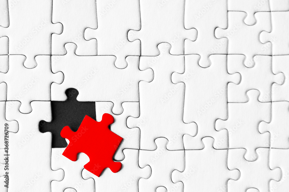 White gray puzzles are stacked on black background. One piece, colored red, located separately. Not like everyone else, outcast. Problem of gender inequality, lgbt .unawareness, racism discrimination. White gray puzzles are stacked on black background. One piece, colored red, located separately. Not like everyone else, outcast. Problem of gender inequality, lgbt .unawareness, racism discrimination.