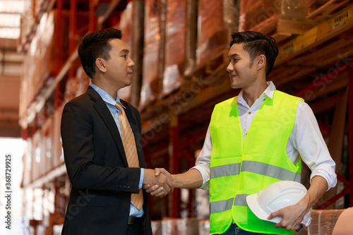 factory worker team hands shaking greeting start up plan new project warehouse behind white safety helmet on workplace walking talking at warehouse site, partnership, contractor concept.