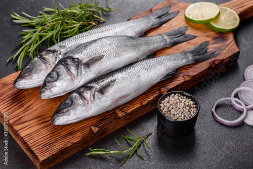 Foto Fresh fish seabass and ingredients for cooking. Raw fish seabass