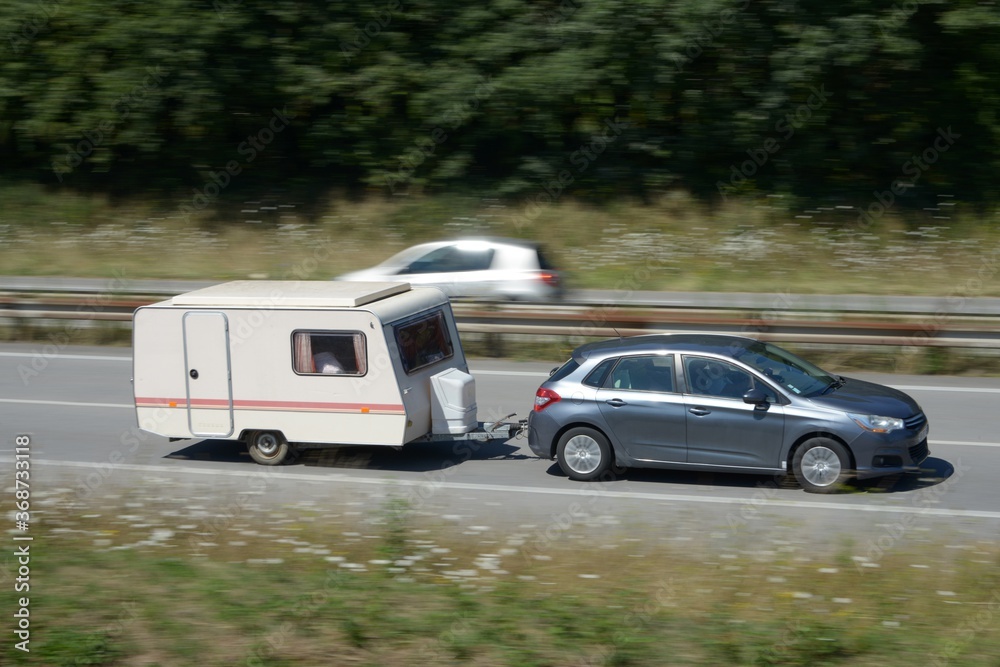 Voiture tractant une caravane sur une voie express