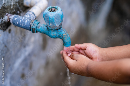 Little kid washing hand under the faucet with water. clean and Hygiene concept.