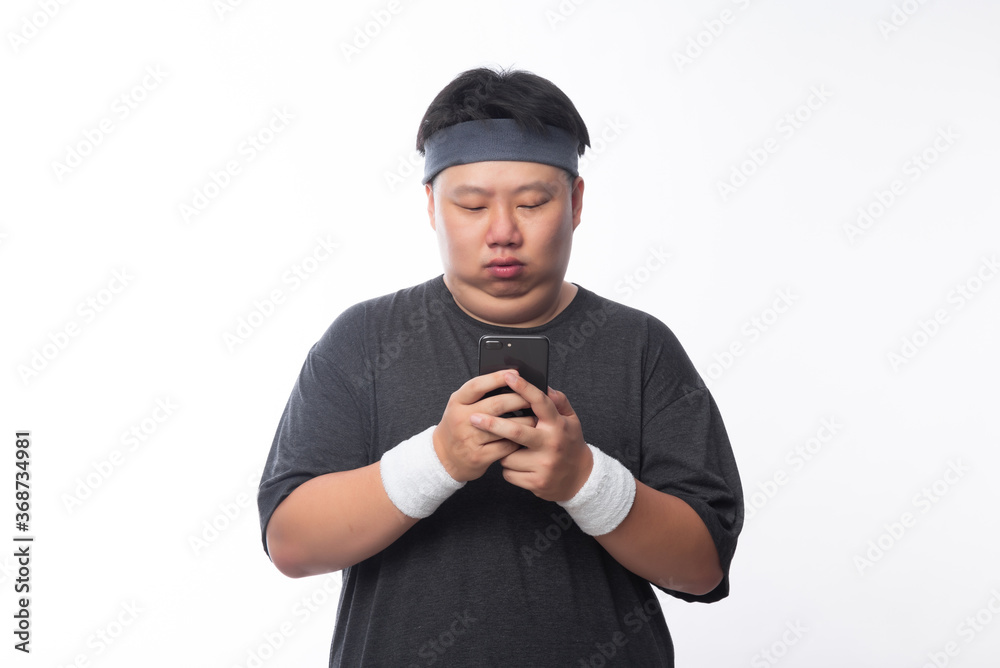 Young Asian funny fat sport man using smartphone isolated on white background. Young Asian funny fat sport man using smartphone isolated on white background.