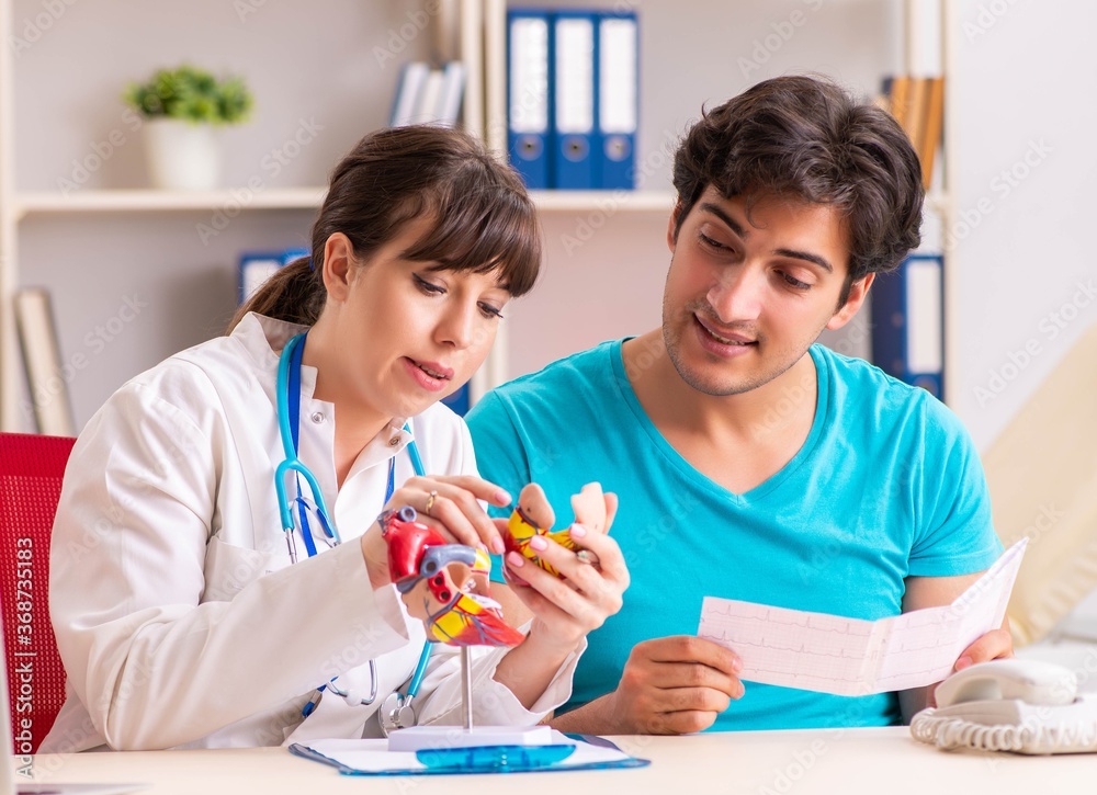 Young man visiting female doctor cardiologist Young man visiting female doctor cardiologist