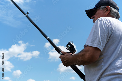 Fishing in river.A fisherman with a fishing rod on the river bank. Man fisherman catches a fish.Fishing, spinning reel, fish, Breg rivers. The concept of a rural getaway. Article about fishing. photo