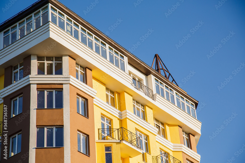 Obraz premium Details of new constructed colorful multi-story building. Modern residential construction. Residential fund. Building of he city. New yellow house