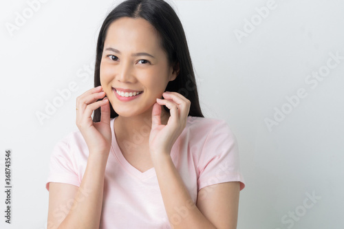Asian woman catches her face smiling.