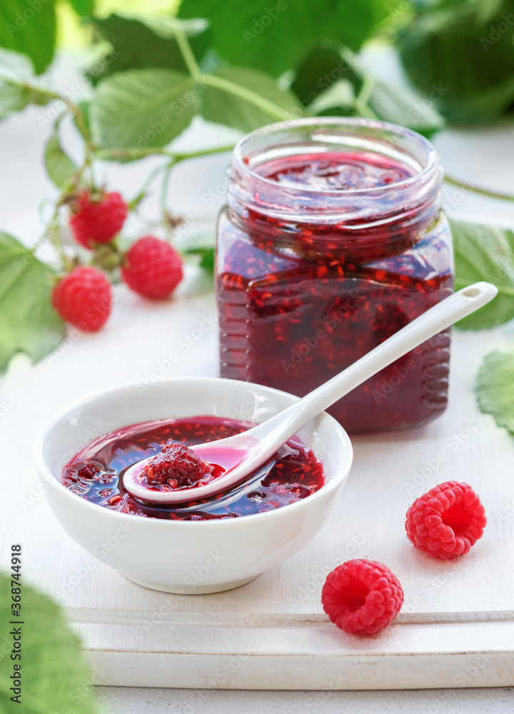 Raspberry jam and fresh berries on white cutting board Raspberry jam and fresh berries on white cutting board
