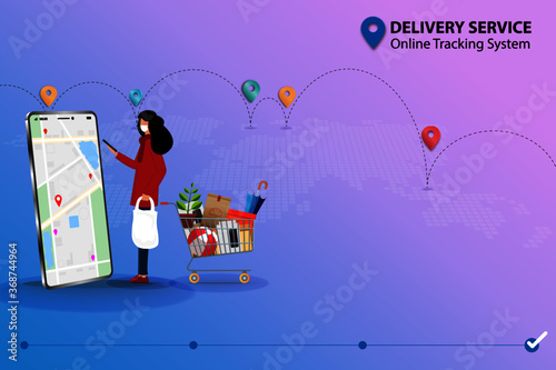 Concept of delivery service and online tracking, young woman standing near super market basket with goods and holding a smartphone to check map and GPS to track the shipment that shown on the display.