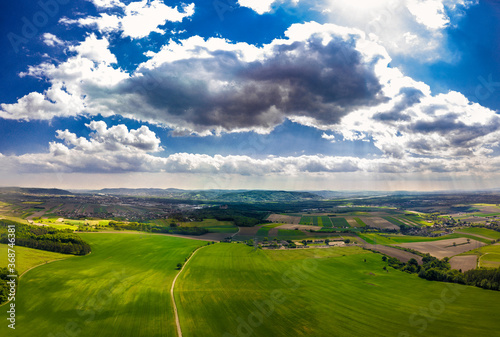 Narrow Gravel Path Between Green Fields in Rural Landscape To City In The Distance In Austria