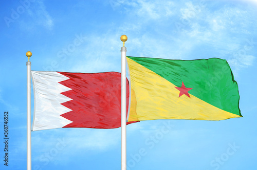 Bahrain and French Guiana two flags on flagpoles and blue sky photo