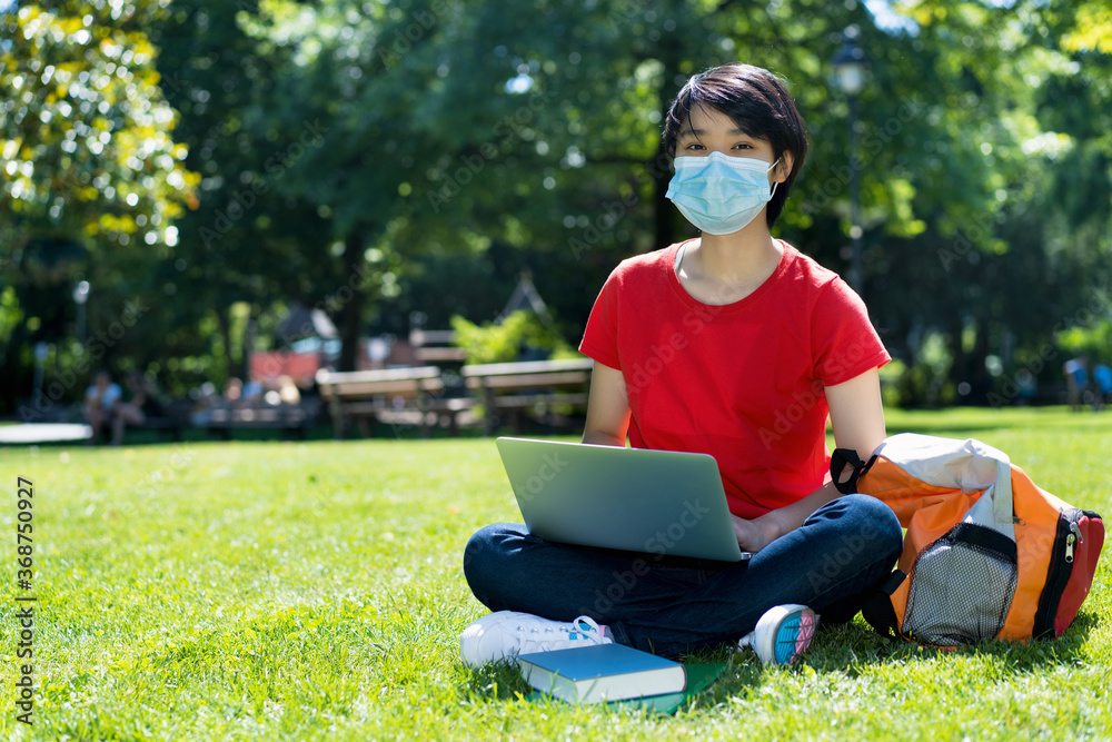 Fototapeta premium East asian male student with face mask at campus of university