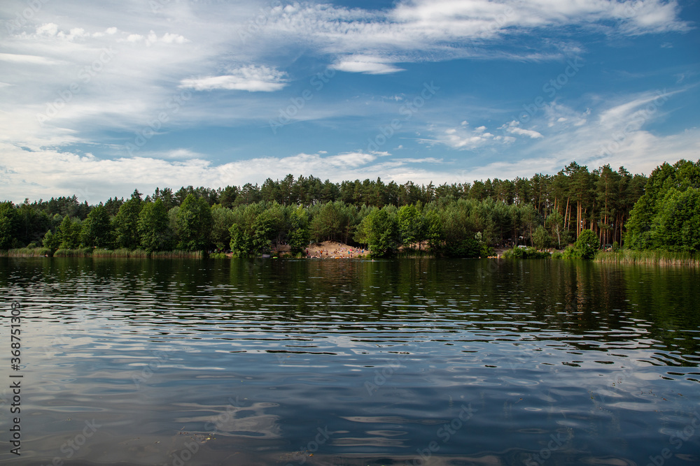 Beautiful lake in the woods with pine trees on the shore for summer vacation. Travel to Ukraine. Beautiful lake in the woods with pine trees on the shore for summer vacation. Travel to Ukraine.